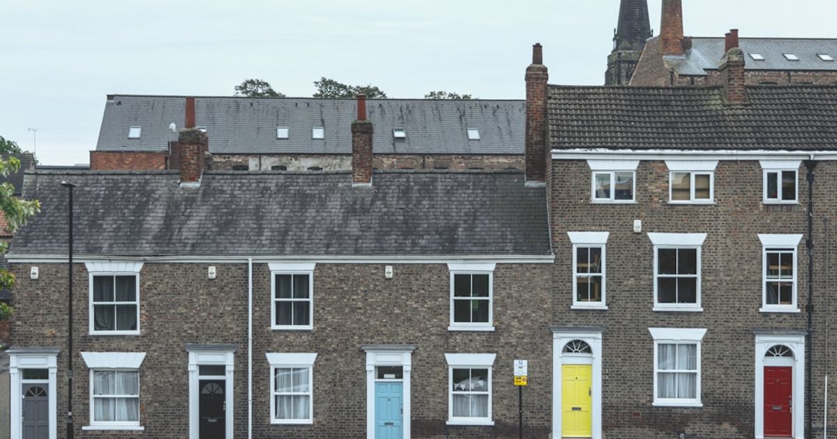 Completed UK residential apartment block exterior, developer exit finance scenario with unsold units